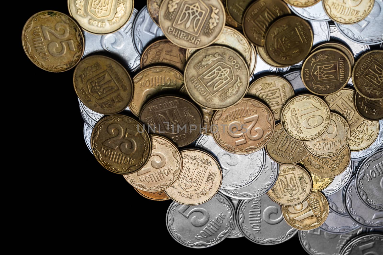 Ukrainian coins isolated on black background. Close-up view. Coins are located at the right side of frame. A conceptual image.