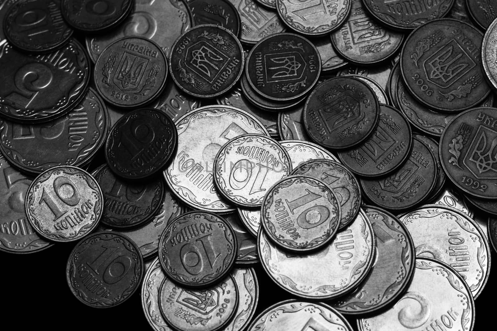 Ukrainian coins isolated on black background. Close-up view. Black and white image. Coins are located above the center of frame. A conceptual image.