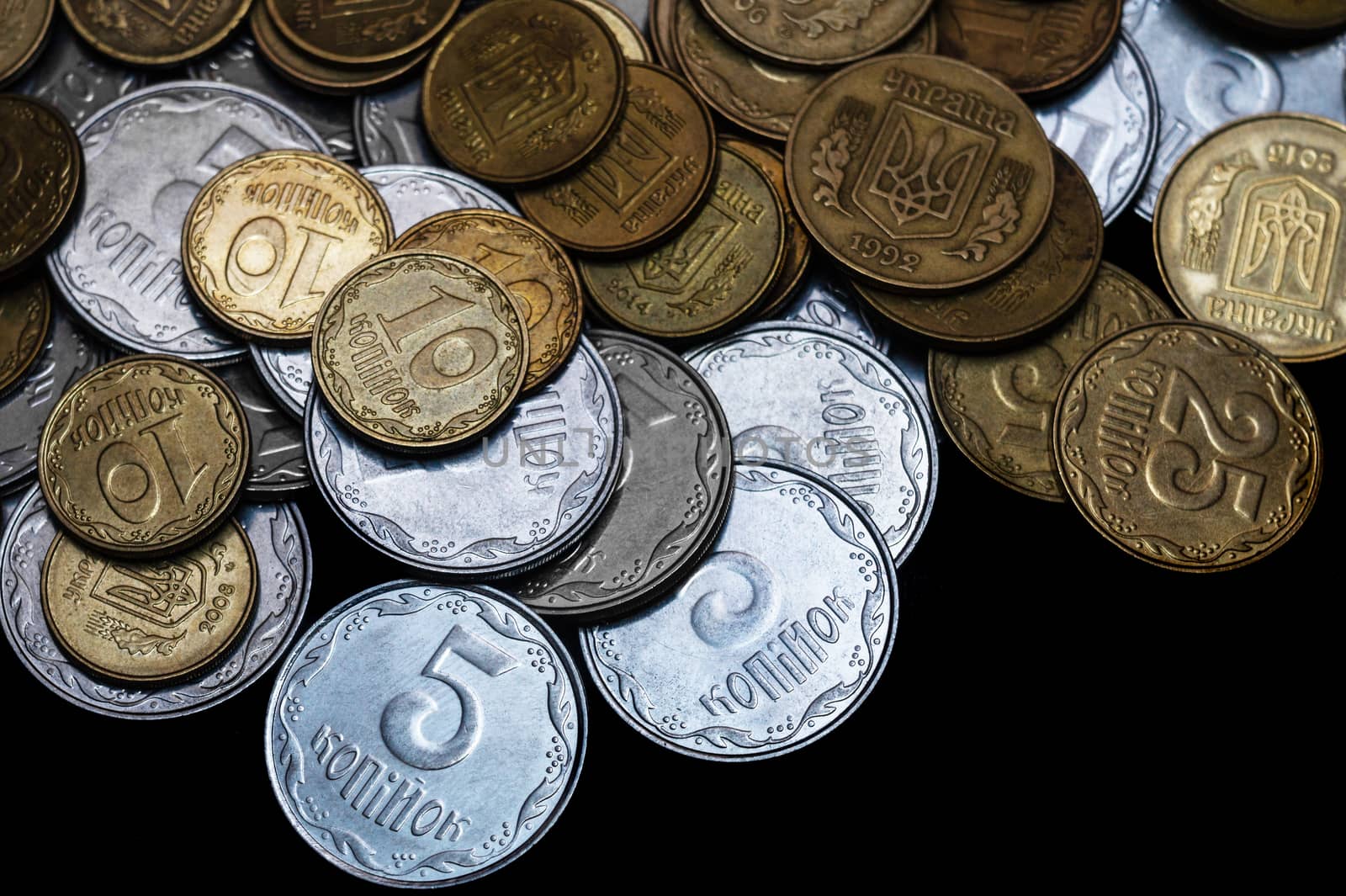 Ukrainian coins isolated on black background. Close-up view. Coins are located above the center of frame. A conceptual image.