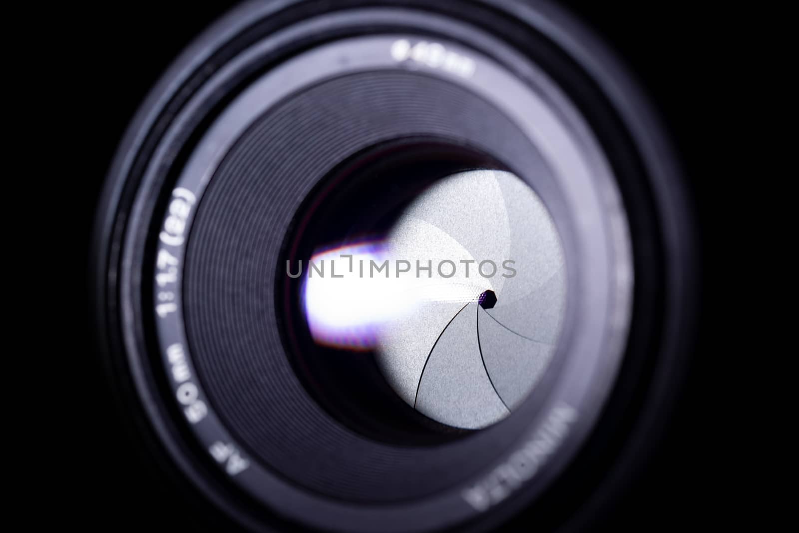 Lens aperture low light photo. Aperture blades is clean. Stock photo with blurred foreground. Isolated on black background.