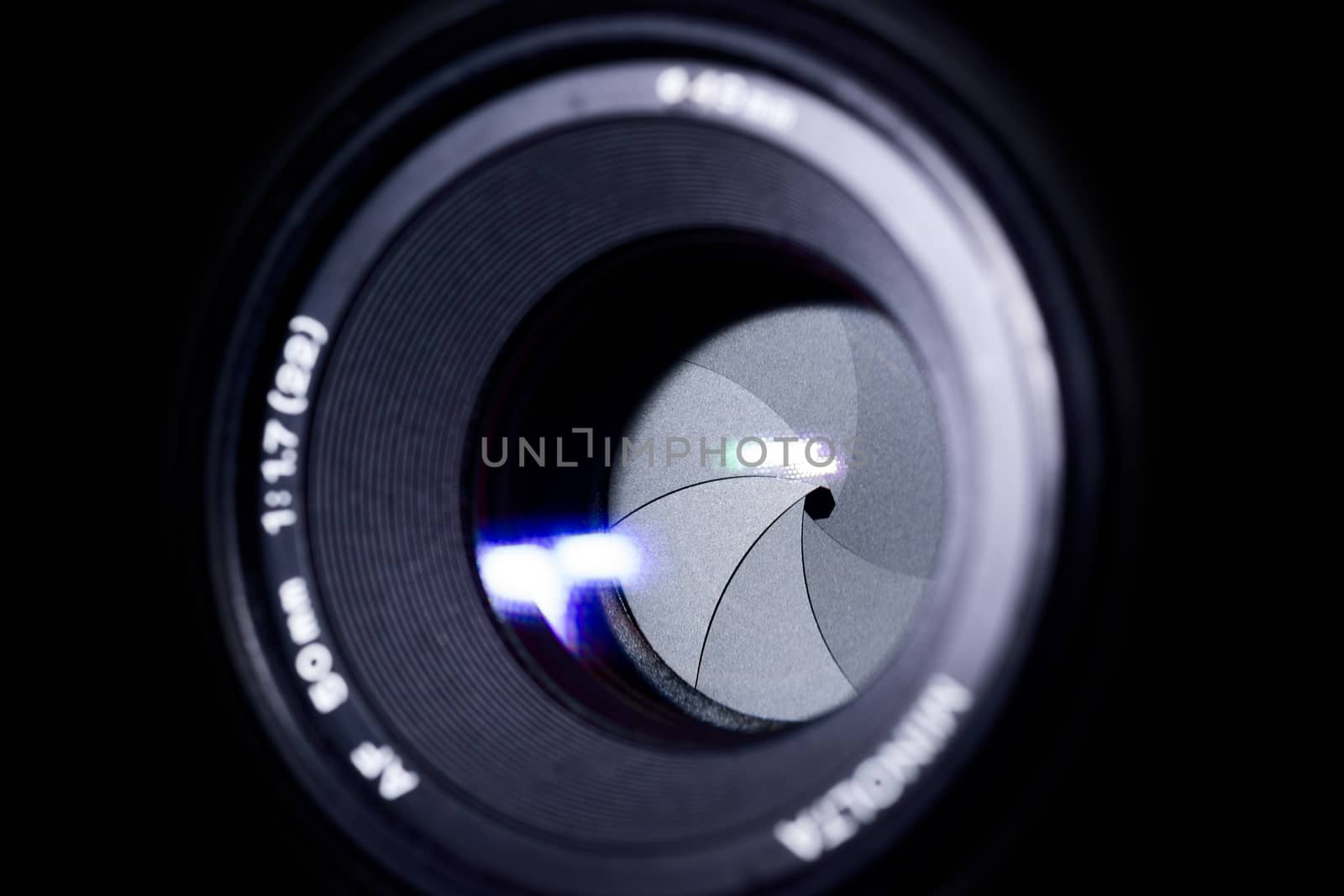 Lens aperture low light photo. Aperture blades is clean. Stock photo with blurred foreground. Isolated on black background.