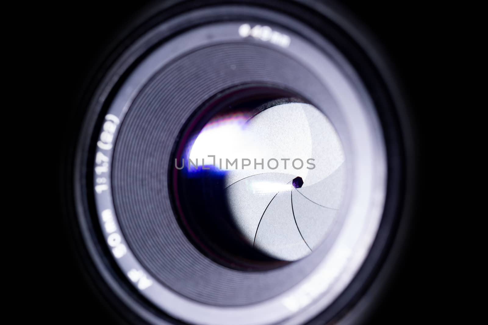 Lens aperture low light photo. Aperture blades is clean. Stock photo with blurred foreground. Isolated on black background.