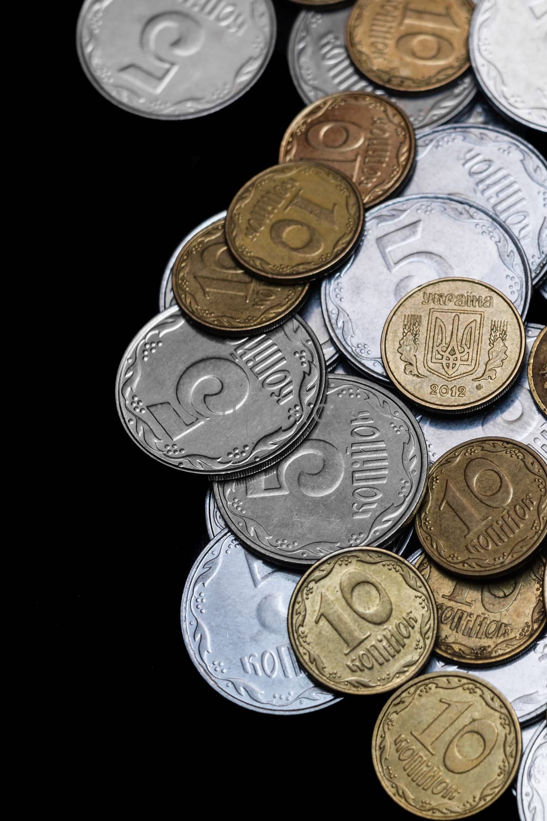 Ukrainian coins isolated on black background. Close-up view. Coins are located at the right side of frame. A conceptual image.