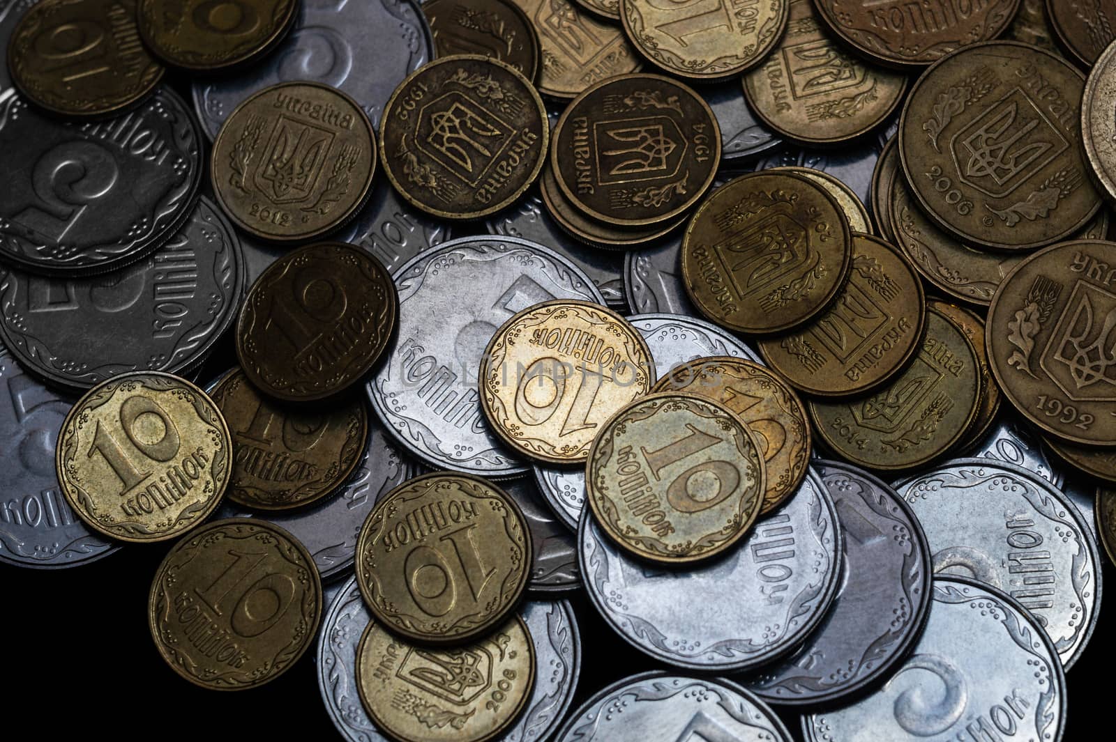 Ukrainian coins isolated on black background. Close-up view. Coins are located above the center of frame. A conceptual image.
