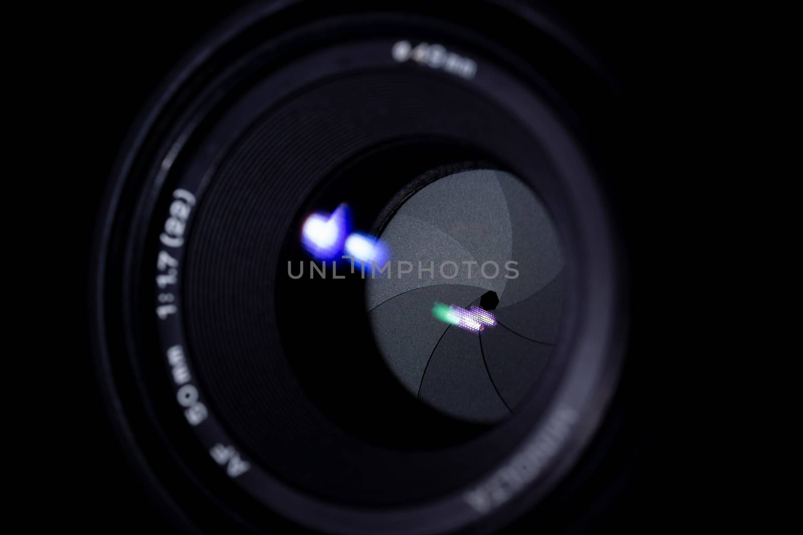 Lens aperture low light photo. Aperture blades is clean. Stock photo with blurred foreground. Isolated on black background.