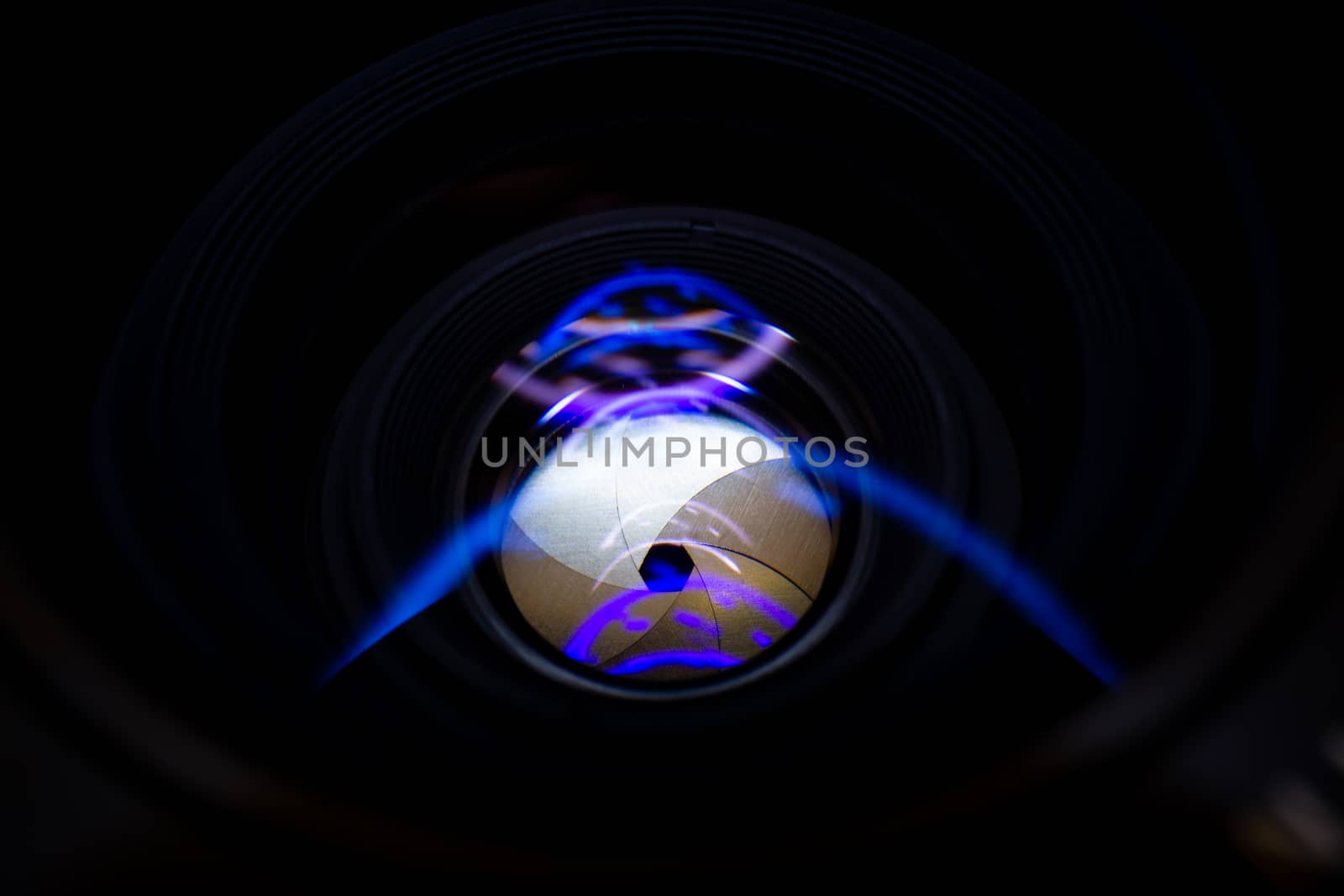 Lens aperture low light photo closeup. Blue traces on glass. Aperture blades is clean. Stock photo isolated on black background.