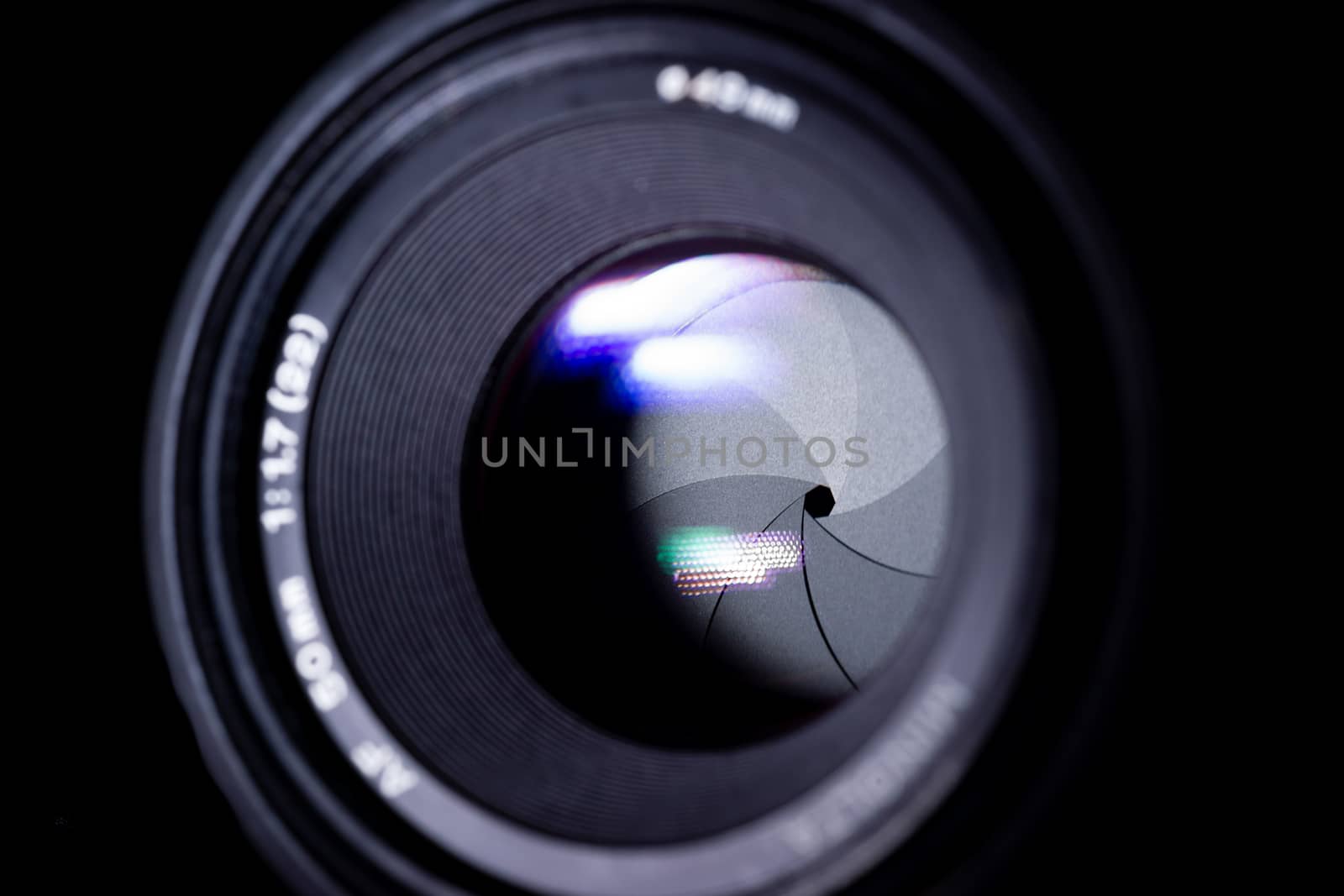 Lens aperture low light photo. Aperture blades is clean. Stock photo with blurred foreground. Isolated on black background.