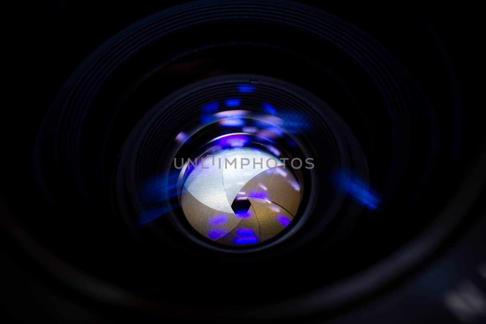 Lens aperture low light photo closeup. Blue traces on glass. Aperture blades is clean. Stock photo isolated on black background.