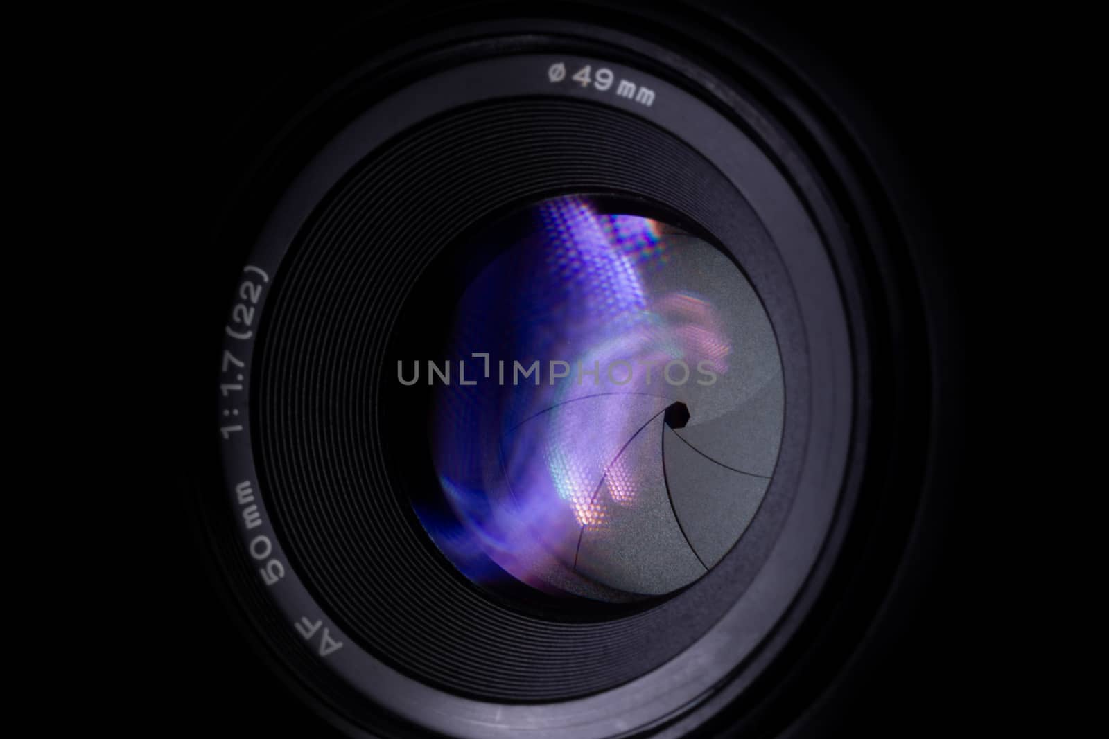 Lens aperture low light photo closeup. Colorful light traces on glass. Aperture blades is clean and dark. Stock photo isolated on black background.