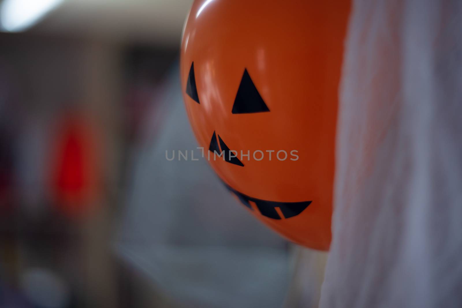 Orange scary halloween air ball with eyes, nose and mouth. Halloween decoration.