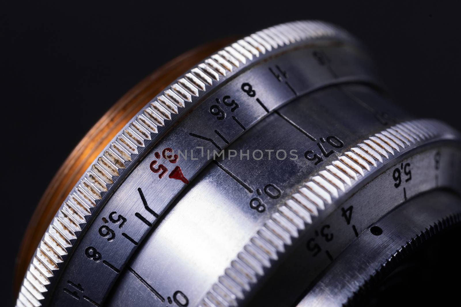 Old vintage lens scales symbols closeup view. Photo with blurred gray background. Aperture symbols and focus distance sign on lens.