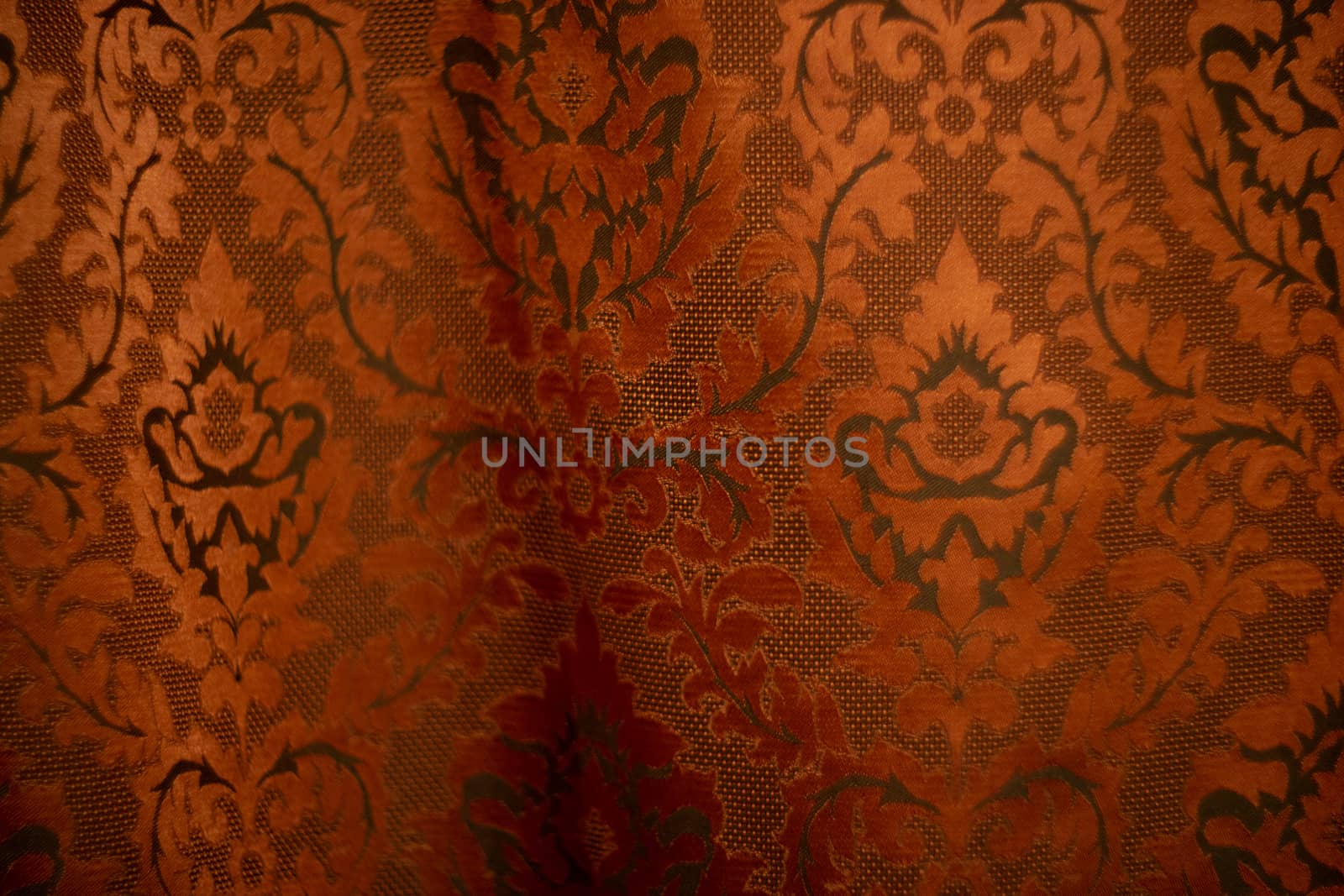 Expensive dark orange home curtains with a very beautiful frilly pattern. Texture shot. Good background or wallpapers.