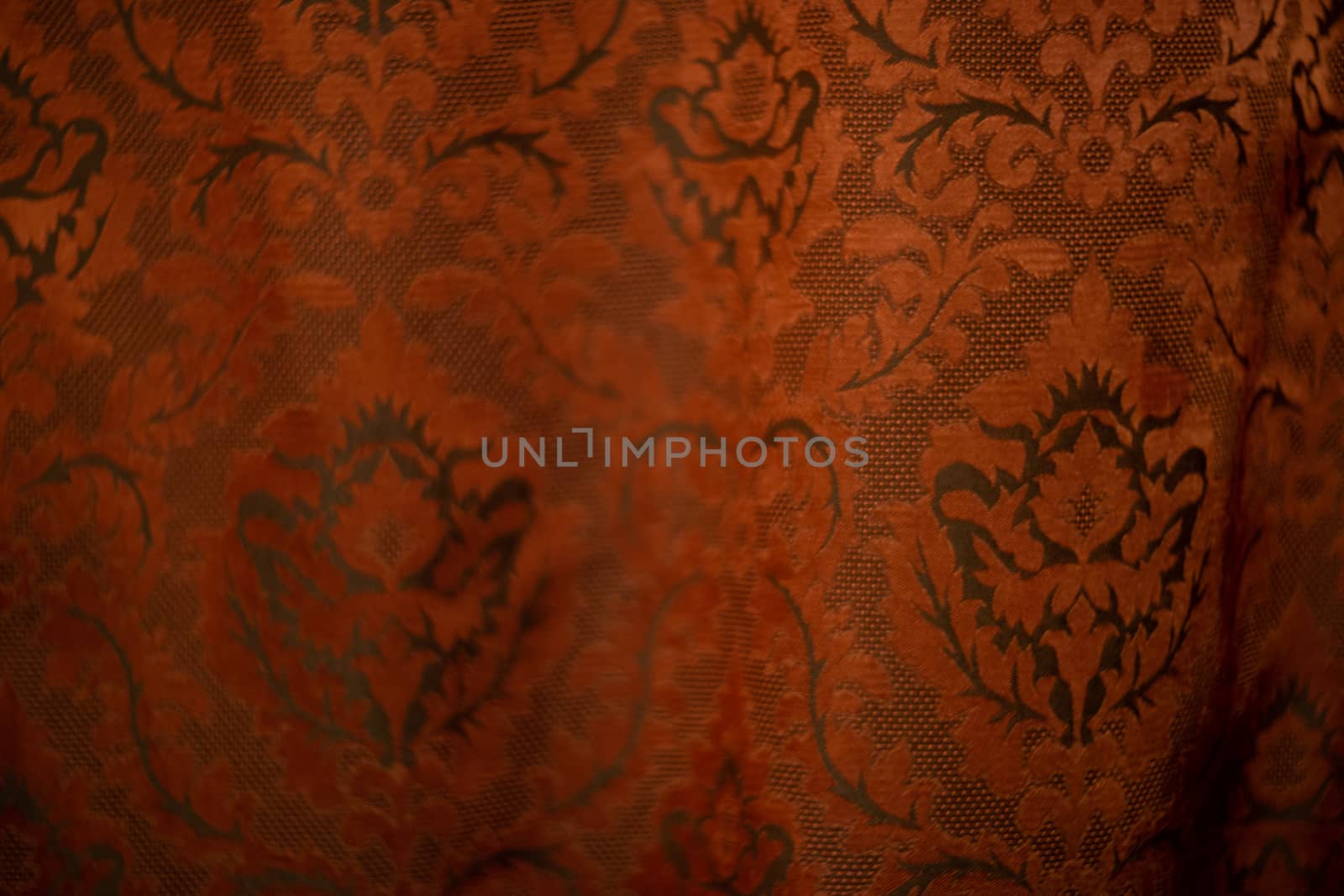 Expensive dark orange home curtains with a very beautiful frilly pattern. Texture shot. Good background or wallpapers.