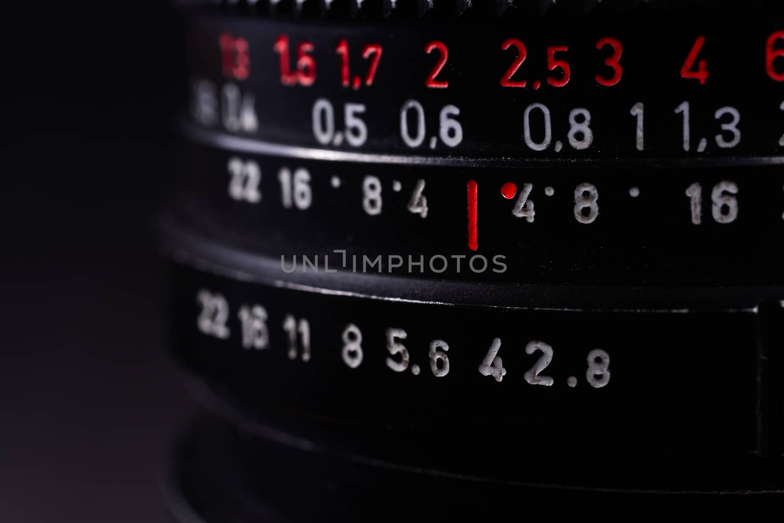 Vintage lens scale signs closeup. Stock photo with blurred gray background.