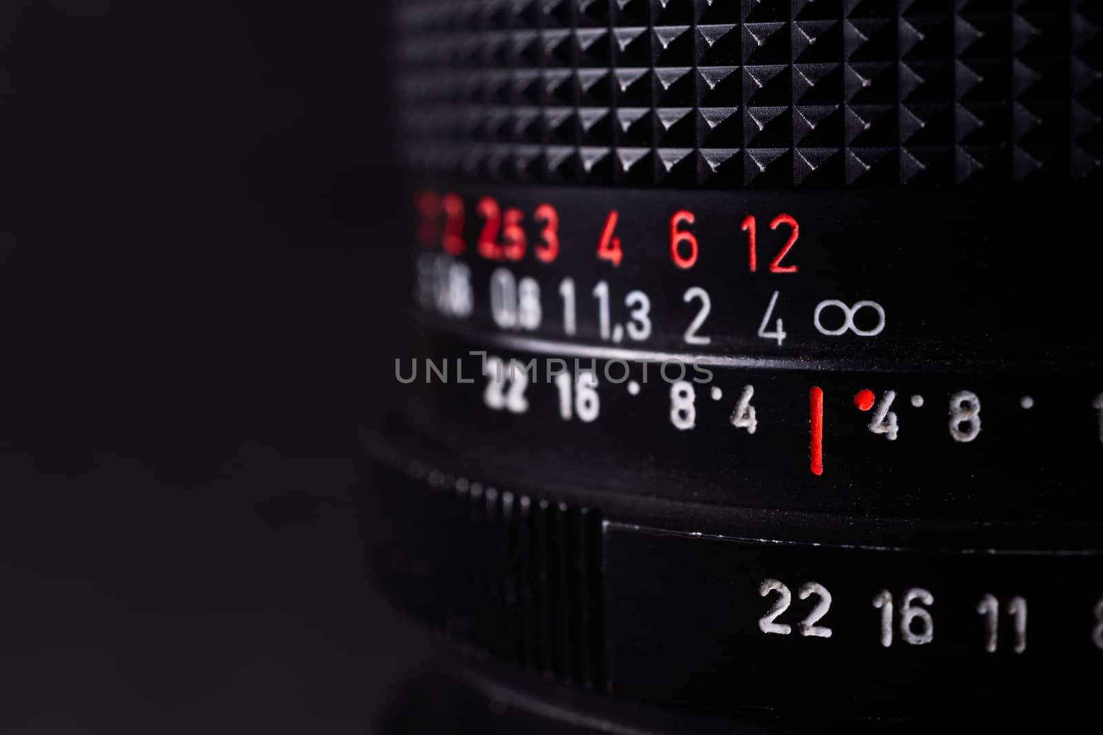 Vintage lens scales symbols closeup. Stock photo with blurred gray background. Aperture symbols and focusing distance signs on lens.