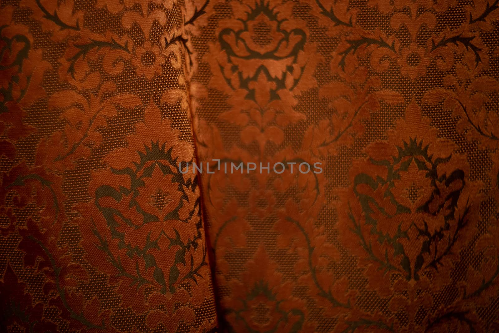 Expensive dark orange home curtains with a very beautiful frilly pattern. Texture shot. Good background or wallpapers.