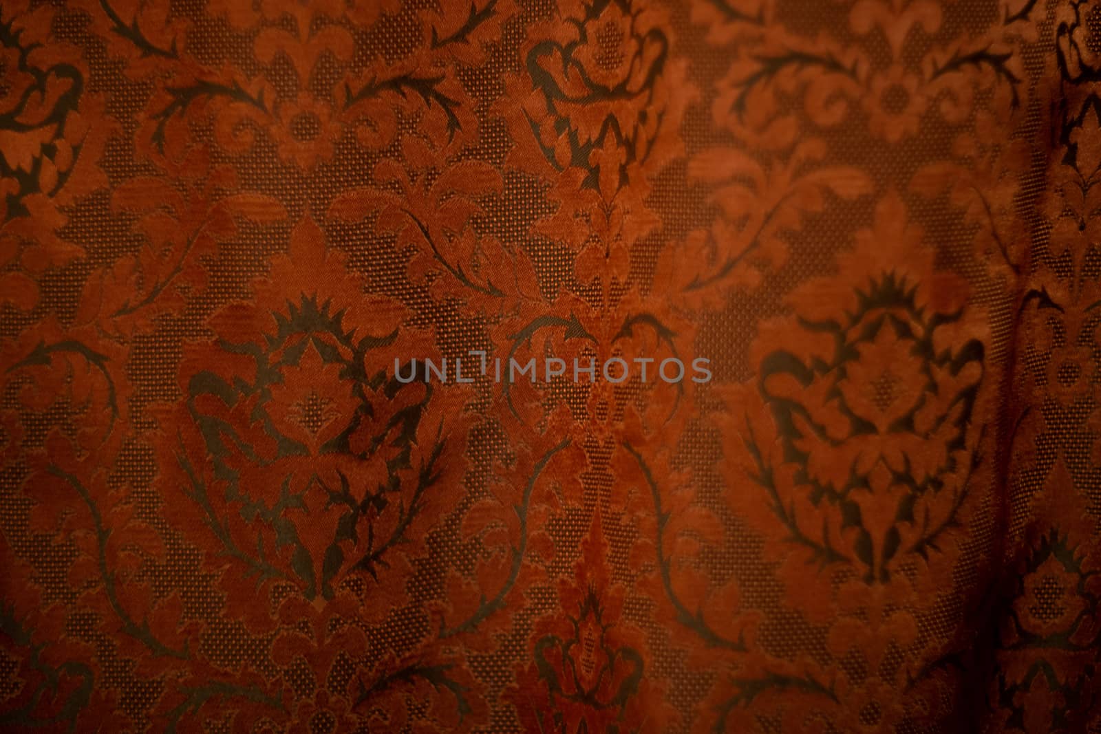 Expensive dark orange home curtains with a very beautiful frilly pattern. Texture shot. Good background or wallpapers.