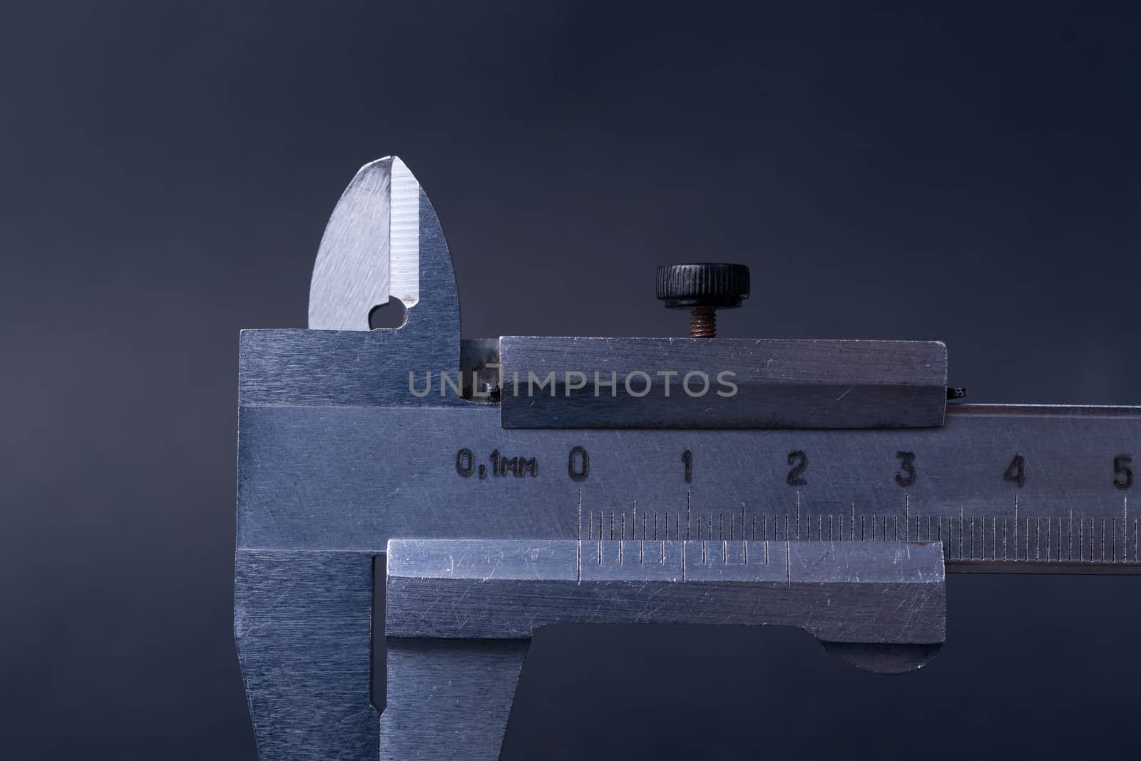 Vintage steel caliper tool closeup. Caliper tips and scale in focus. Tool in very good condition. Scale in metric units, milimeter step. Stock photo on blurred gray background. by alexsdriver