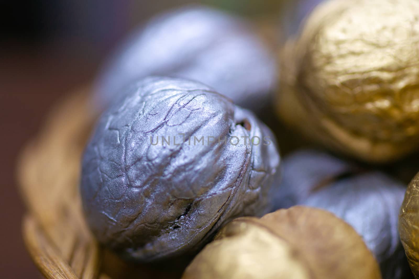 Silver and golden holiday candy nuts in a wicker basket.