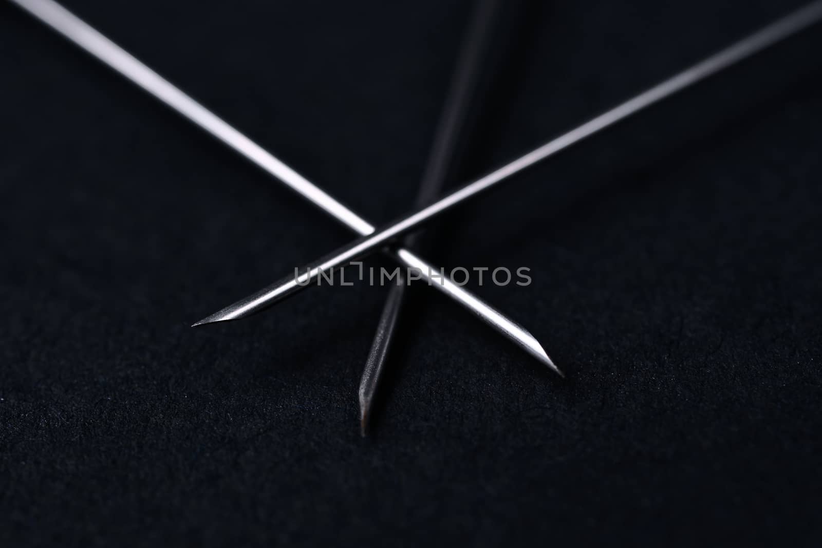 Old rare metallic medical needles isolated on gray background. Needles new and clean. Top view. Sharp needle tips and defocused background.