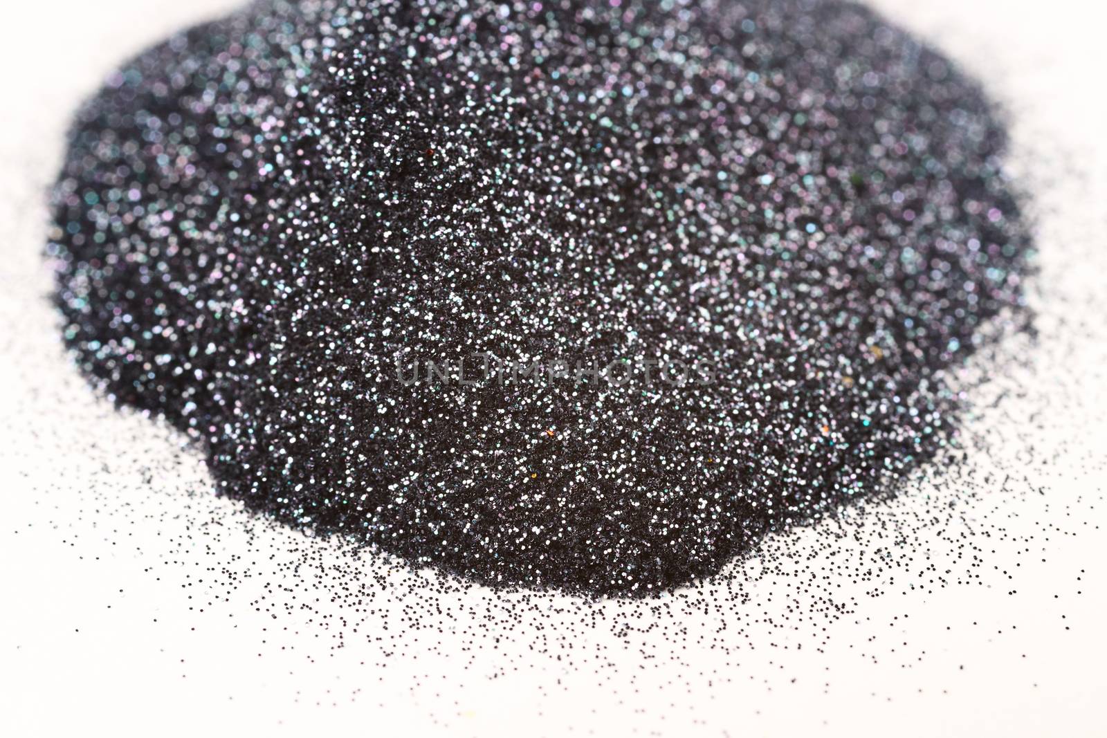 A bunch of silver blue nail gritter for manicure. Gray tone glitter shining on daylight. Stock photo isolated on white background. Varnish topping on paper.