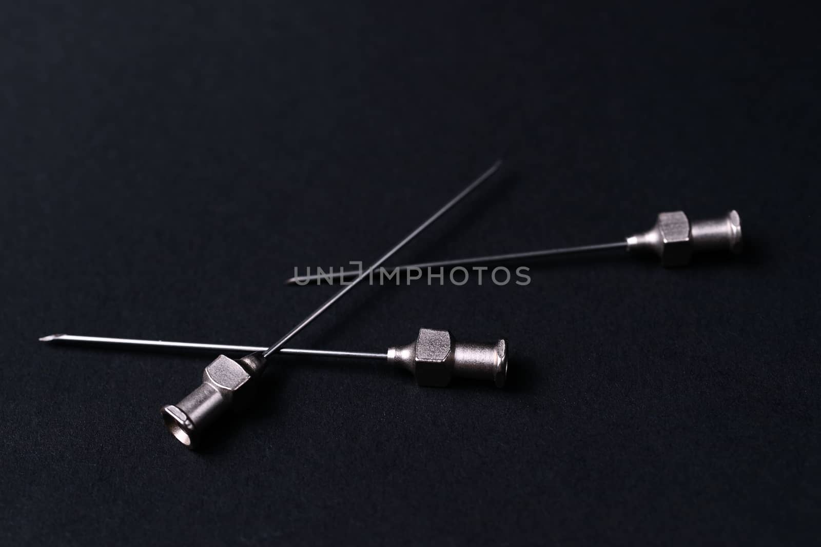 Old rare metallic medical needles isolated on gray background. Needles new and clean.