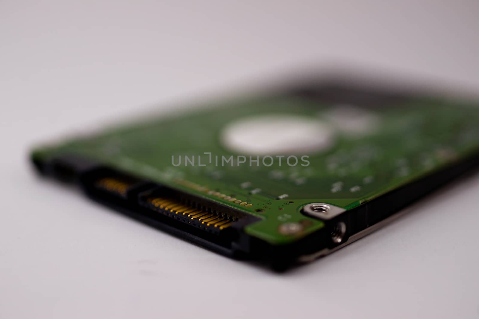 2.5mm laptop HDD on white blurred background. A lot of space on photo is defocused or have soft focus. by alexsdriver