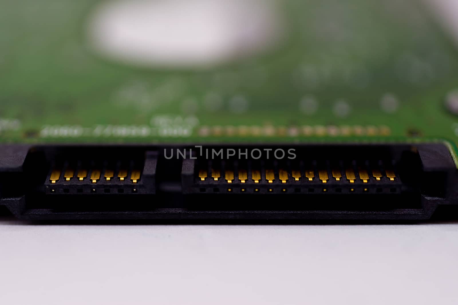 2.5mm laptop HDD on white blurred background. A lot of space on photo is defocused or have soft focus.