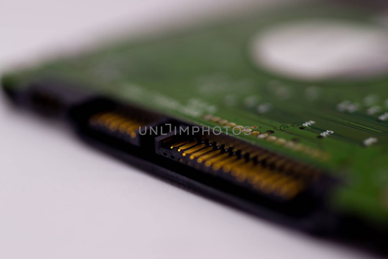 2.5mm laptop HDD on white blurred background. A lot of space on photo is defocused or have soft focus.