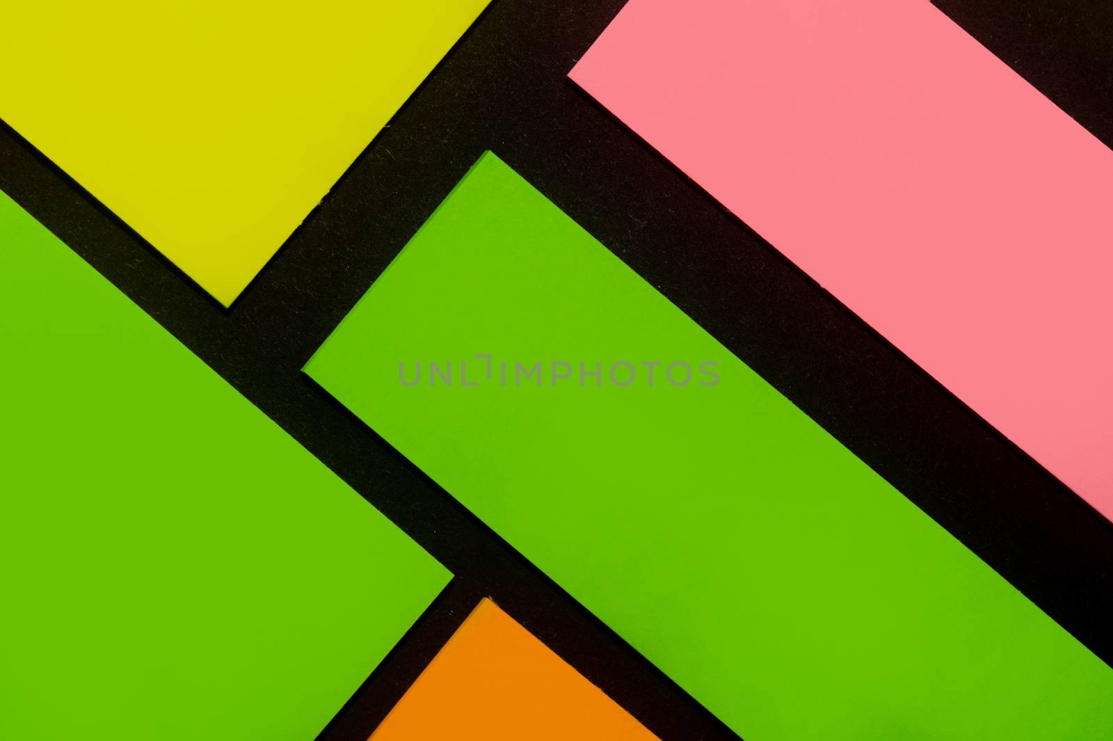 Green, yellow, orange and rose hue colorful office stickers on black paper. Office noteparer as reminder. Isolated on black paper.