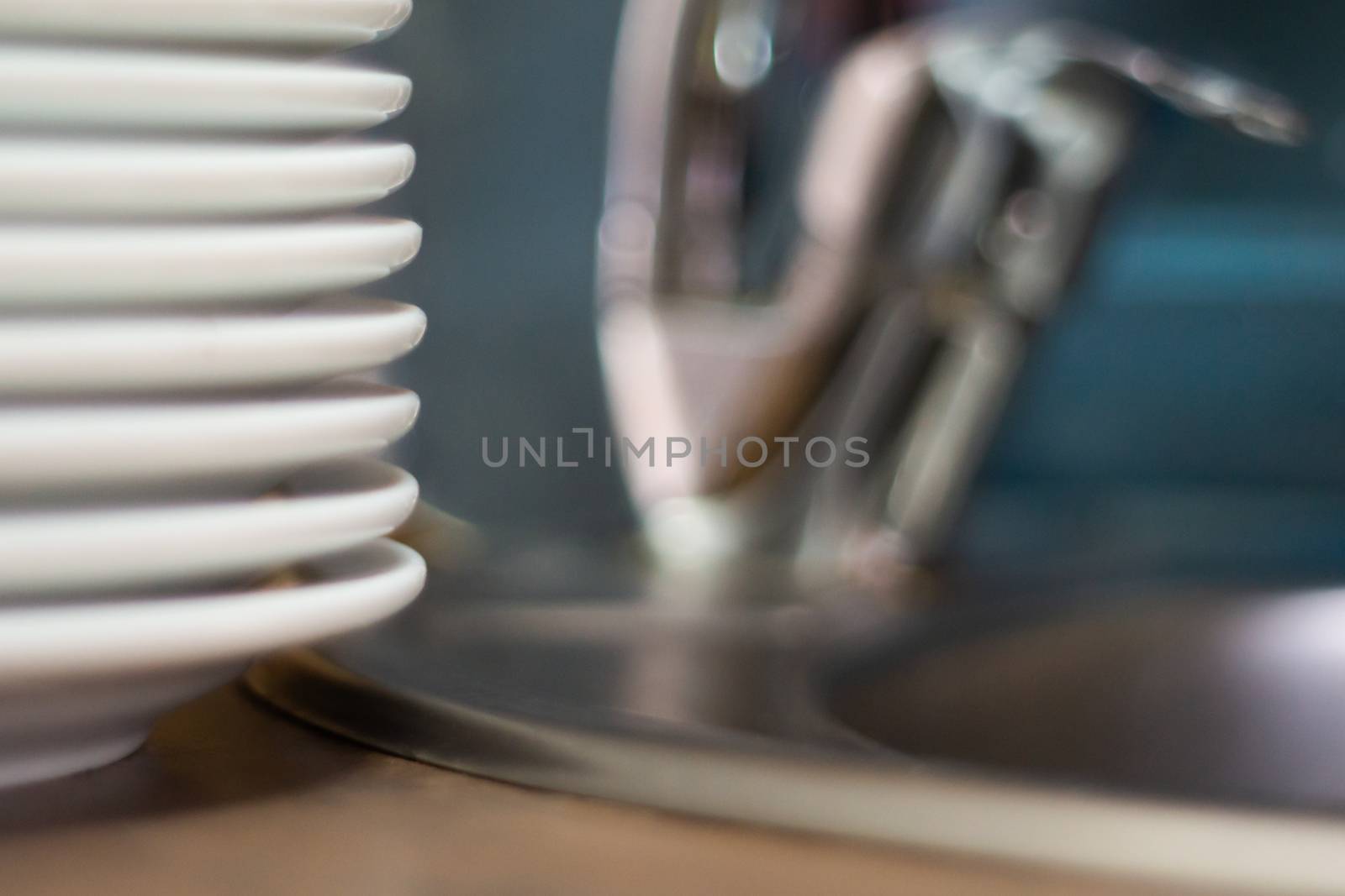 A lot of clean dish on table near sink in cafe. Close-up view