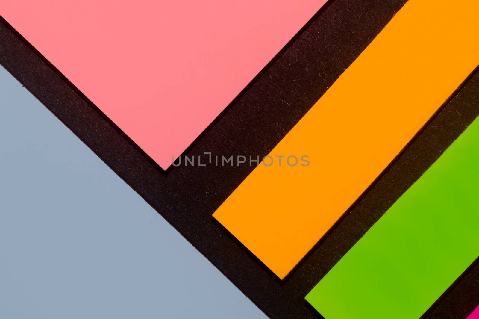 Blue, orange, green and rose hue colorful office stickers on black paper. Office noteparer as reminder. Isolated on black paper.