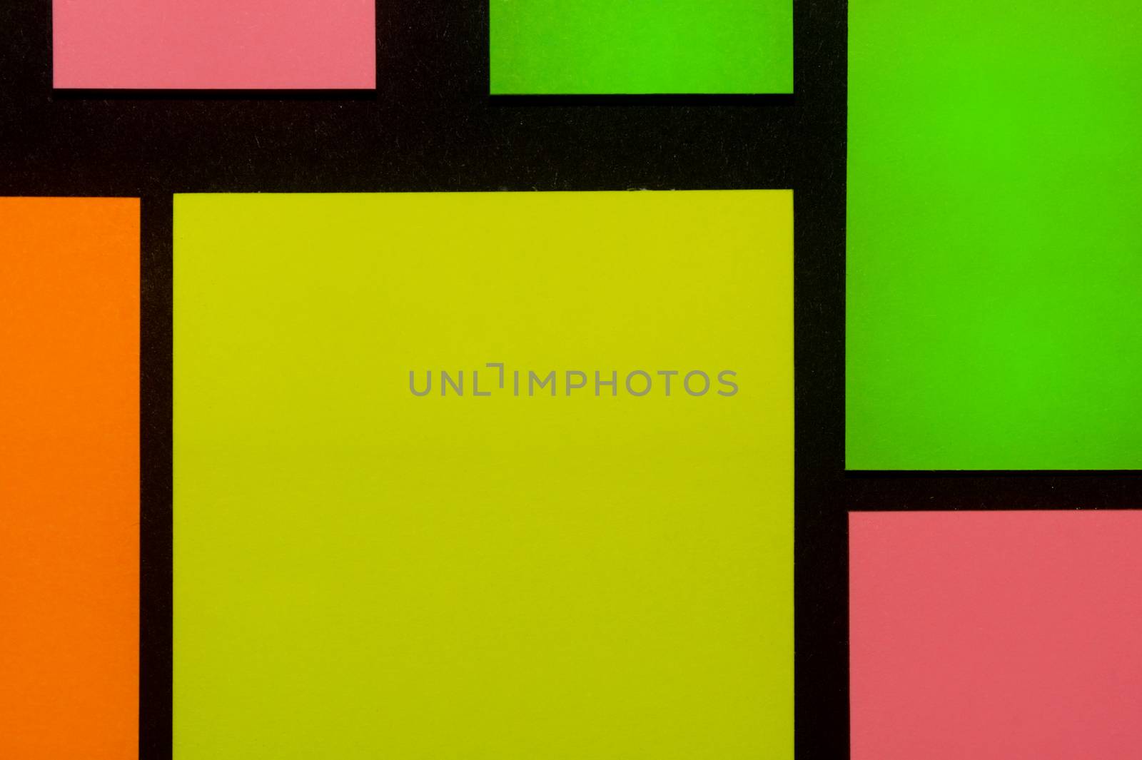 Green, yellow, orange and rose hue colorful office stickers on black paper. Office noteparer as reminder. Isolated on black paper.