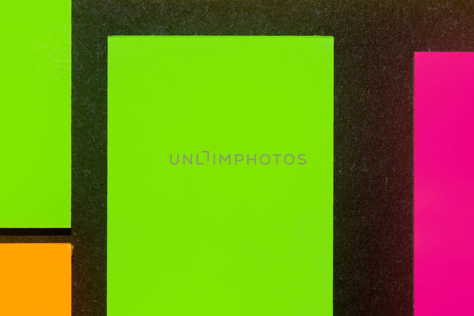 Green, orange and purple hue colorful office stickers on black paper. Office noteparer as reminder. Isolated on black paper.