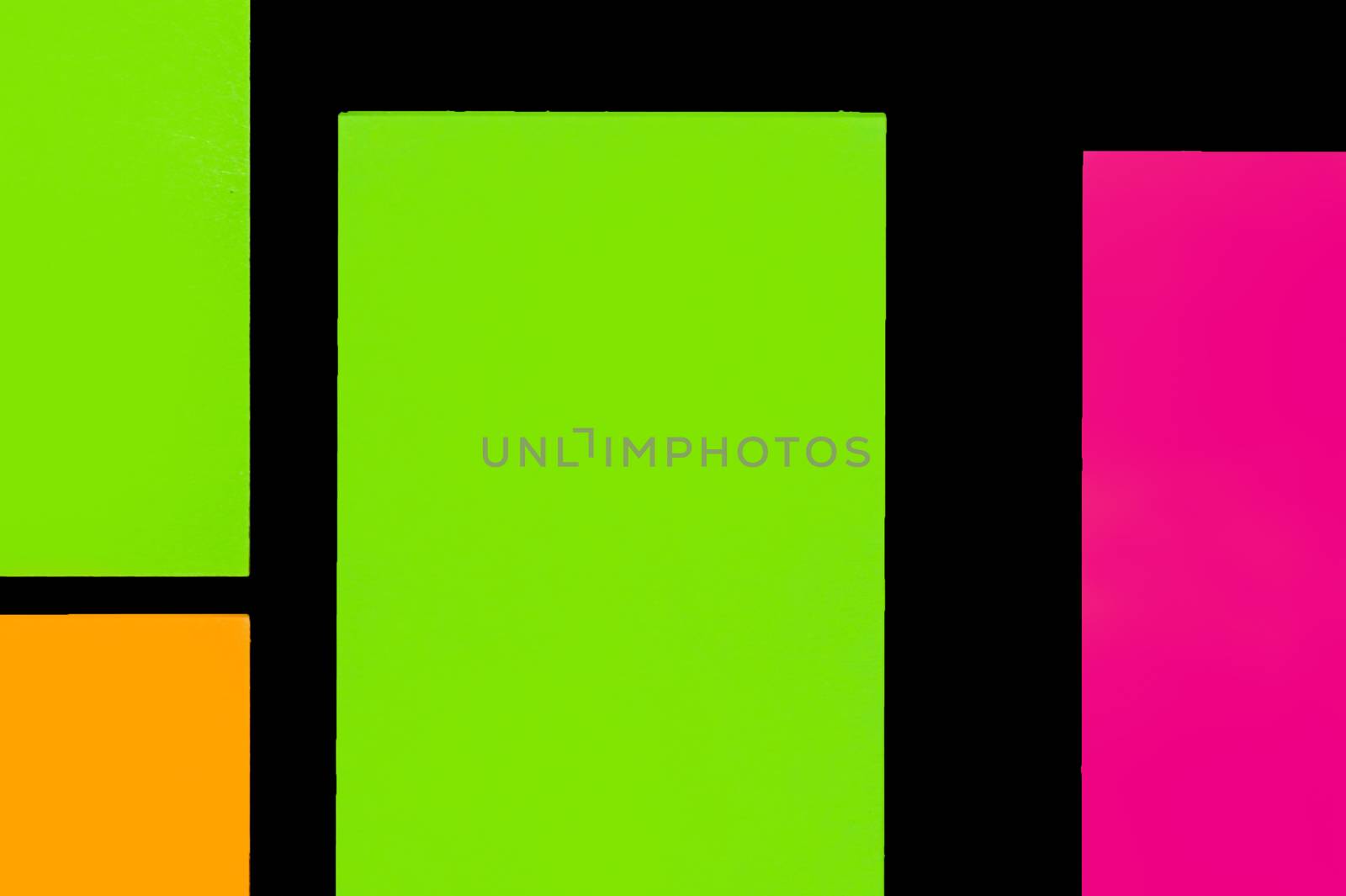Green, orange and purple hue colorful office stickers on black paper. Office noteparer as reminder. Isolated on black paper.