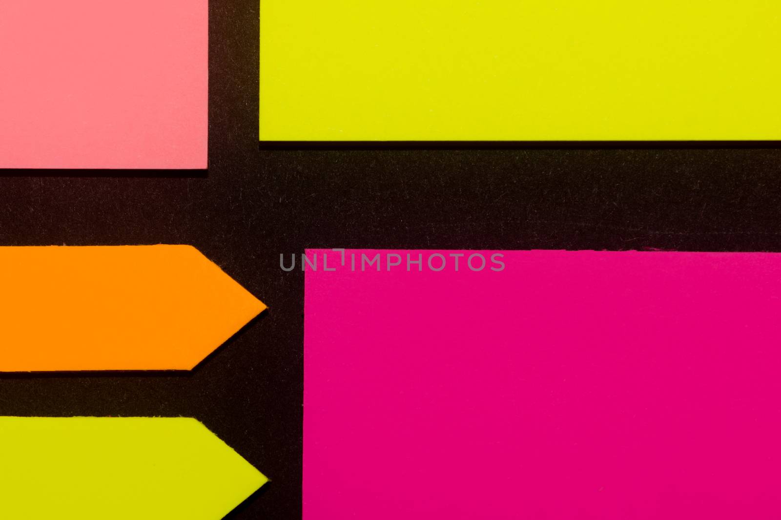 Purple, yellow, orange and rose hue colorful office stickers on black paper. Office noteparer as reminder. Isolated on black paper.