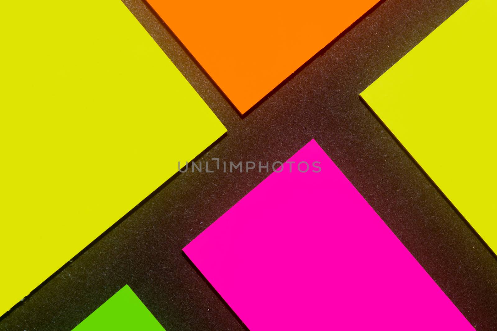 Green, yellow, orange and purple hue colorful office stickers on black paper. Office noteparer as reminder. Isolated on black paper.