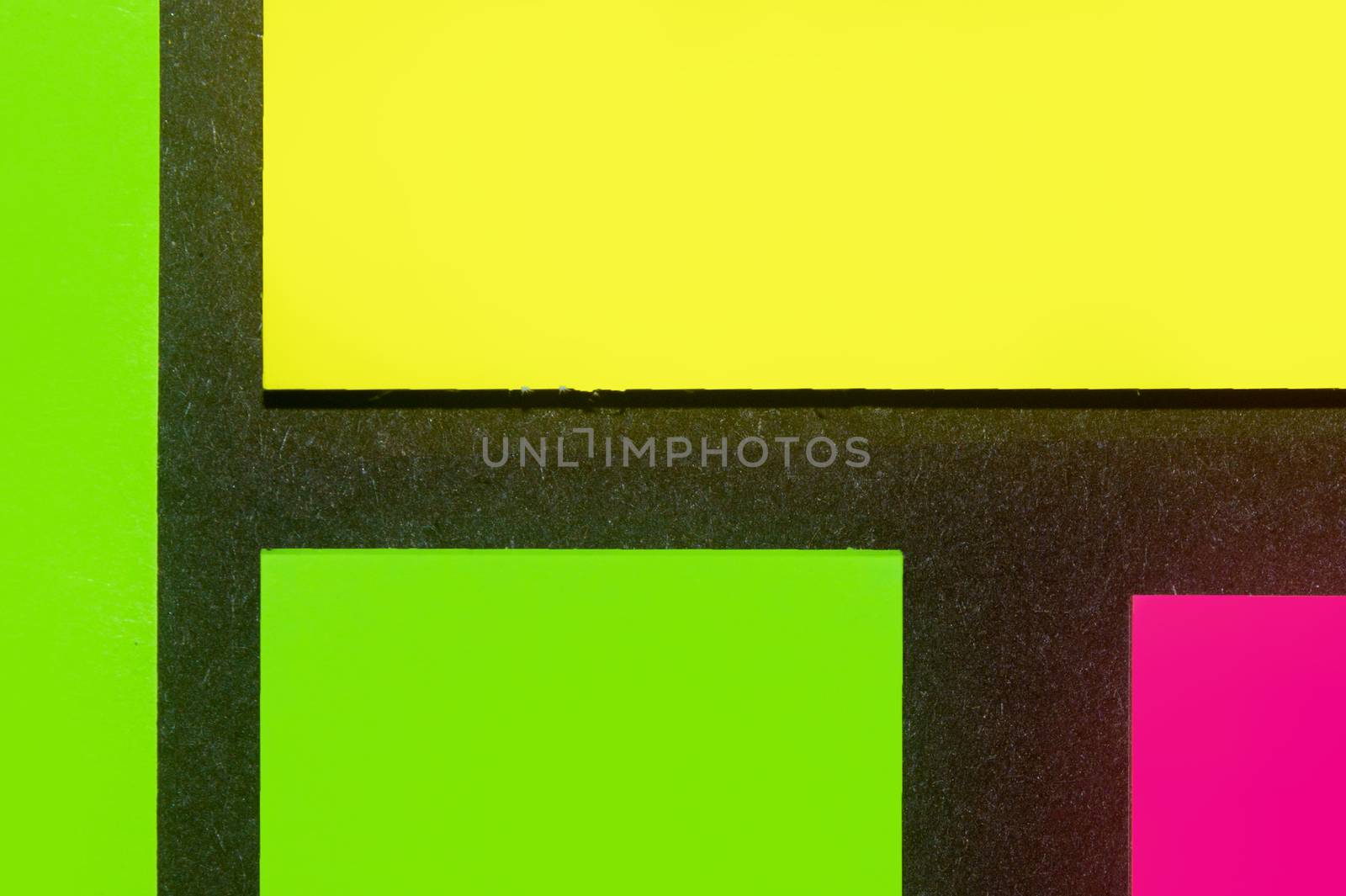 Green, yellow and purple hue colorful office stickers on black paper. Office noteparer as reminder. Isolated on black paper.