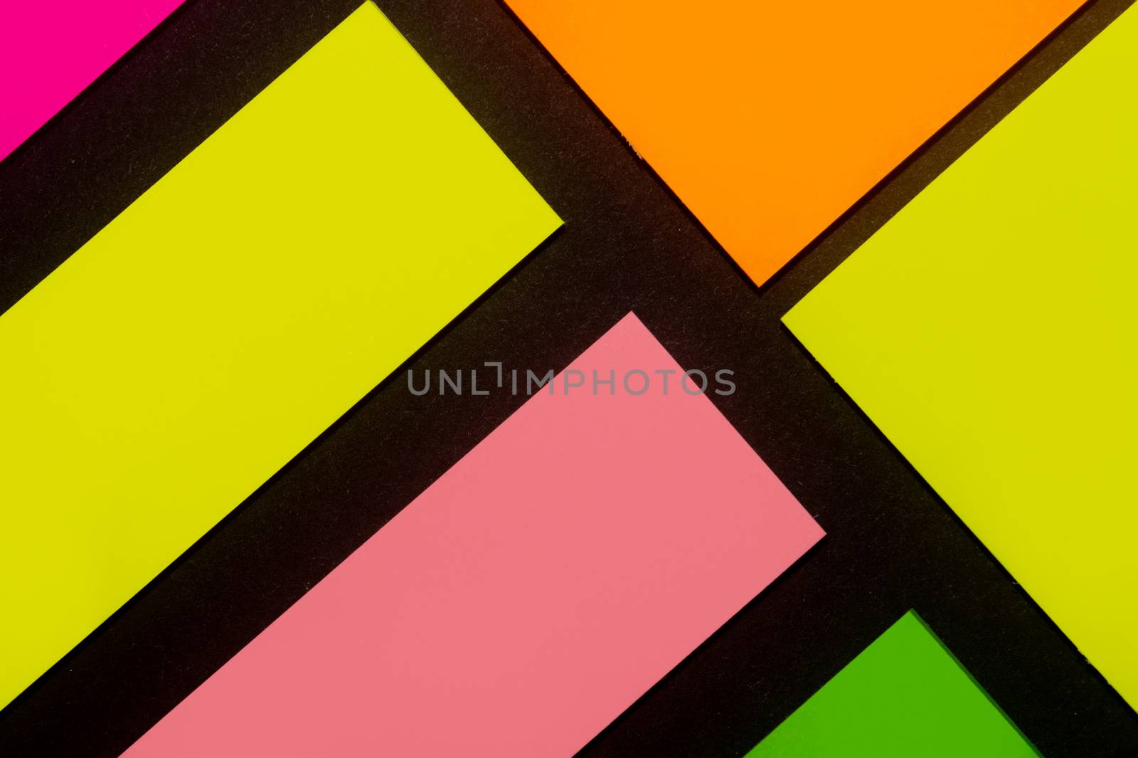 Green, yellow, orange purple and rose hue colorful office stickers on black paper. Office noteparer as reminder. Isolated on black paper.