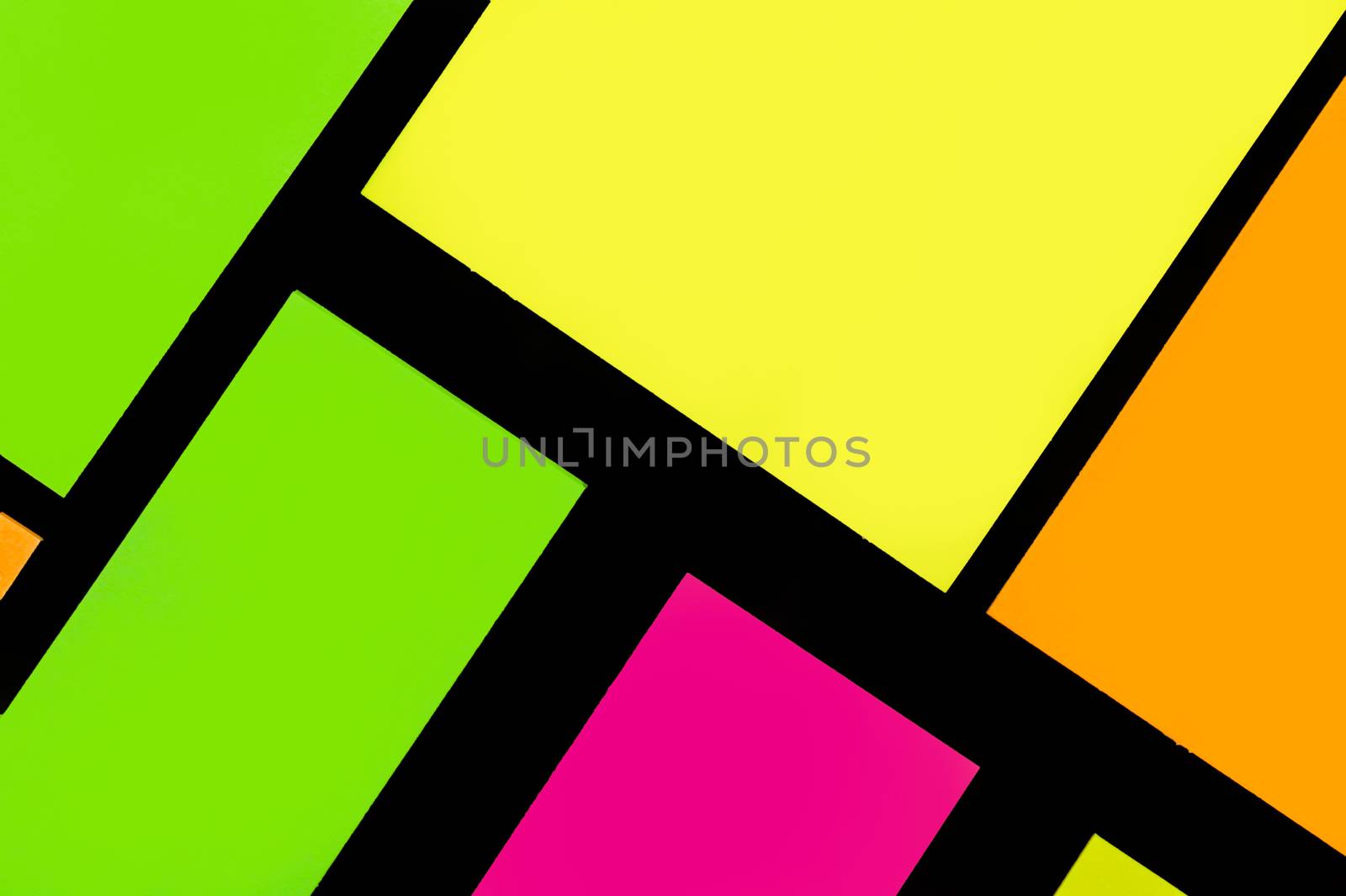 Green, yellow, orange and purple hue colorful office stickers on black paper. Office noteparer as reminder. Isolated on black paper.