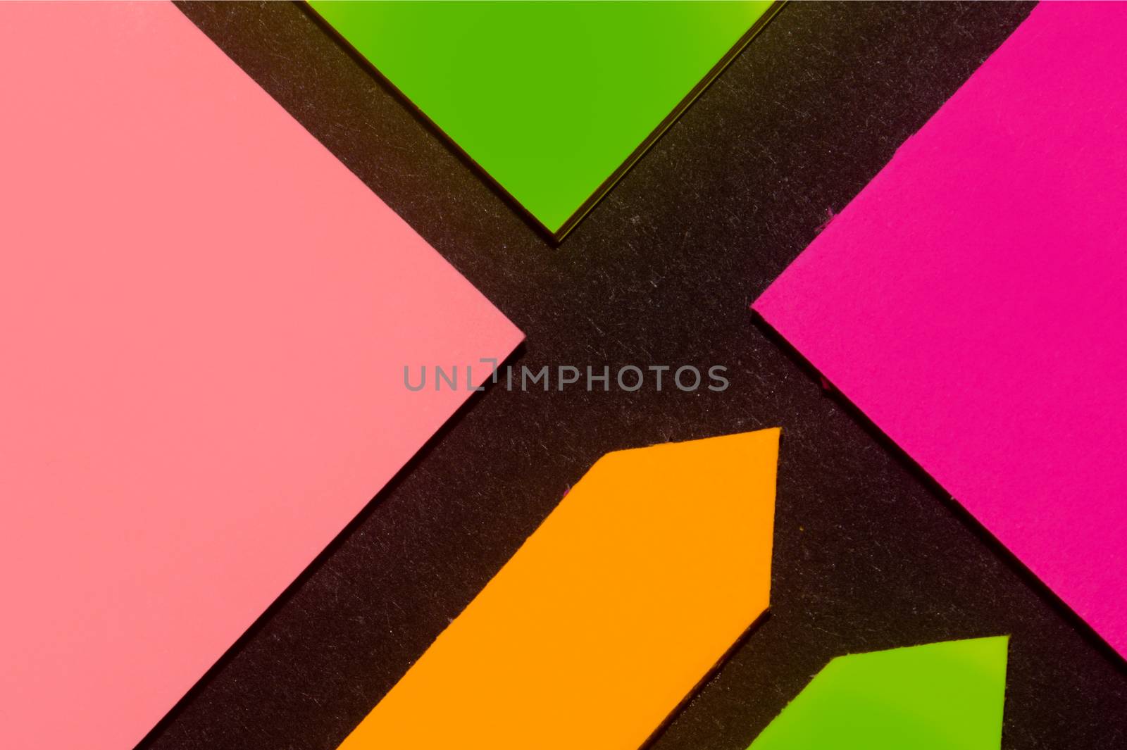 Green, purple, orange and rose hue colorful office stickers on black paper. Office noteparer as reminder. Isolated on black paper.
