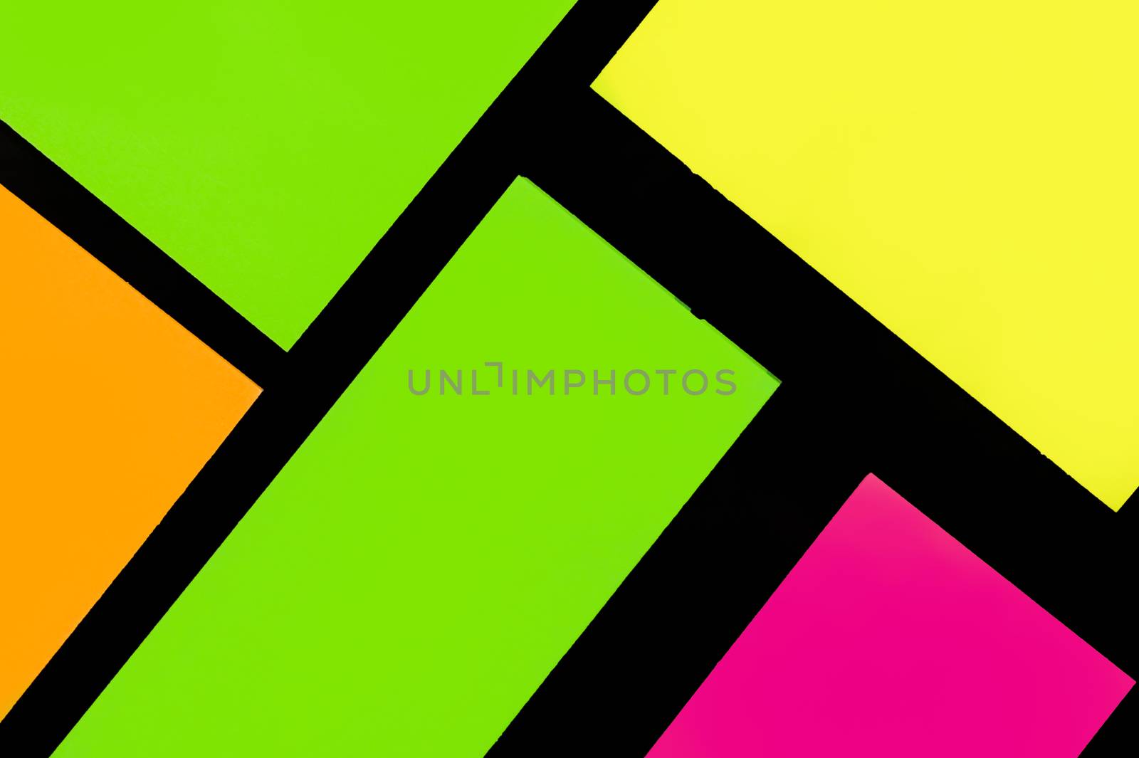 Green, yellow, orange and purple hue colorful office stickers on black paper. Office noteparer as reminder. Isolated on black paper.