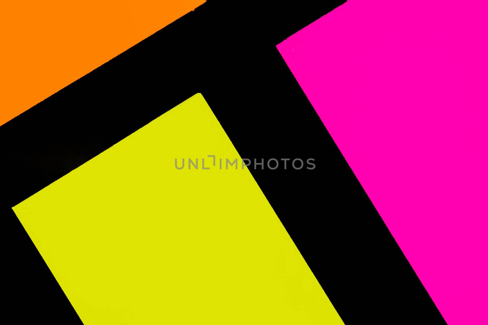 Yellow, orange and purple hue colorful office stickers on black paper. Office noteparer as reminder. Isolated on black paper.