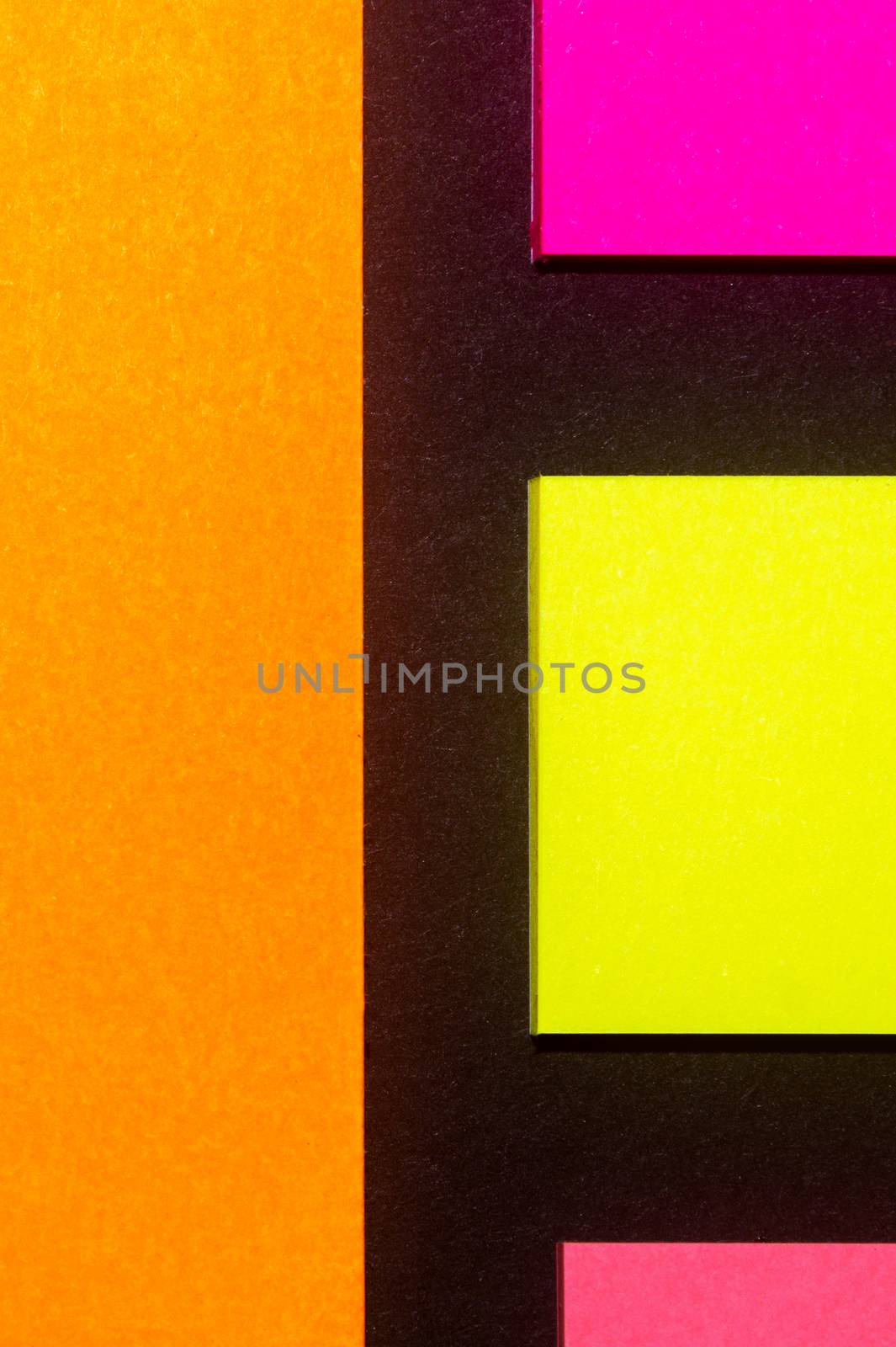 Yellow, orange and rose hue colorful office stickers on black paper. Office noteparer as reminder. Isolated on black paper.