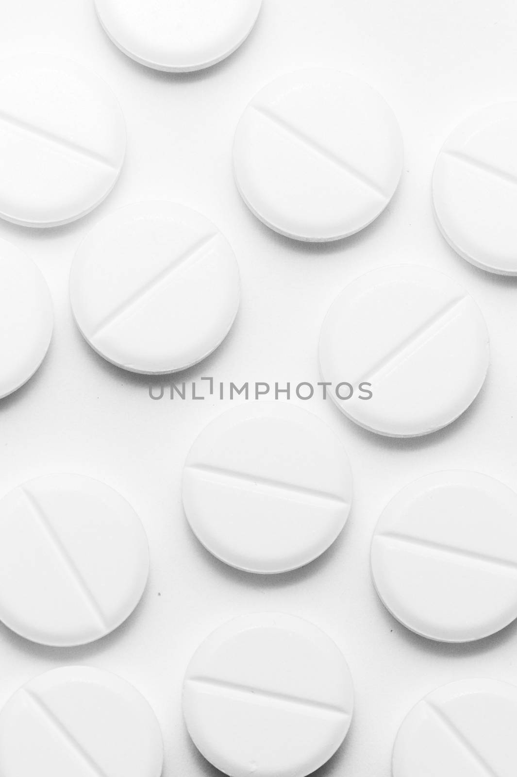 White pills on white background. Close-up view. Medical background. Healthcare image. by alexsdriver
