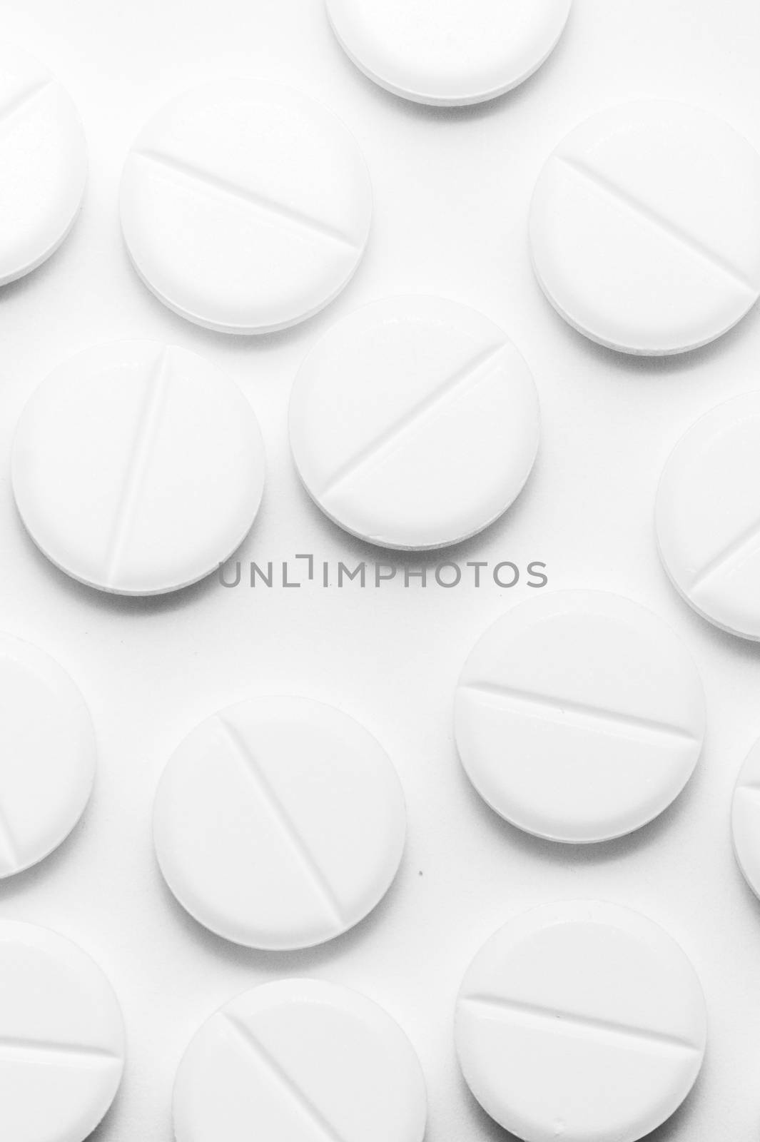 White pills on white background. Close-up view. Medical background. Healthcare image.