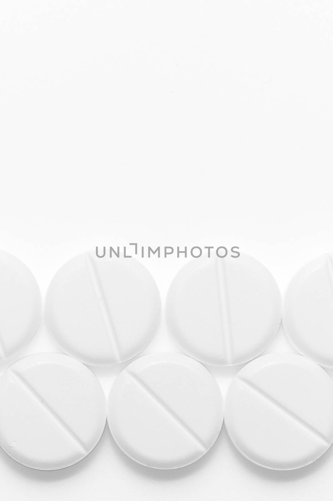 White pills on white background. Close-up view. Medical background. Healthcare image.