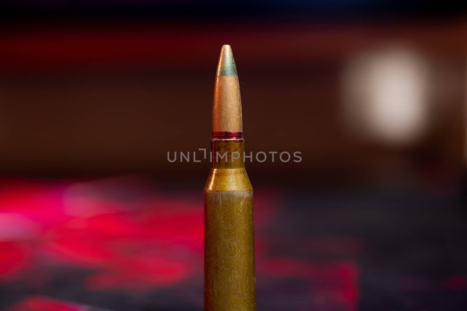 Rifle AK-47 ammo bullet close-up on blurred background. Armor piercing cartridge. by alexsdriver