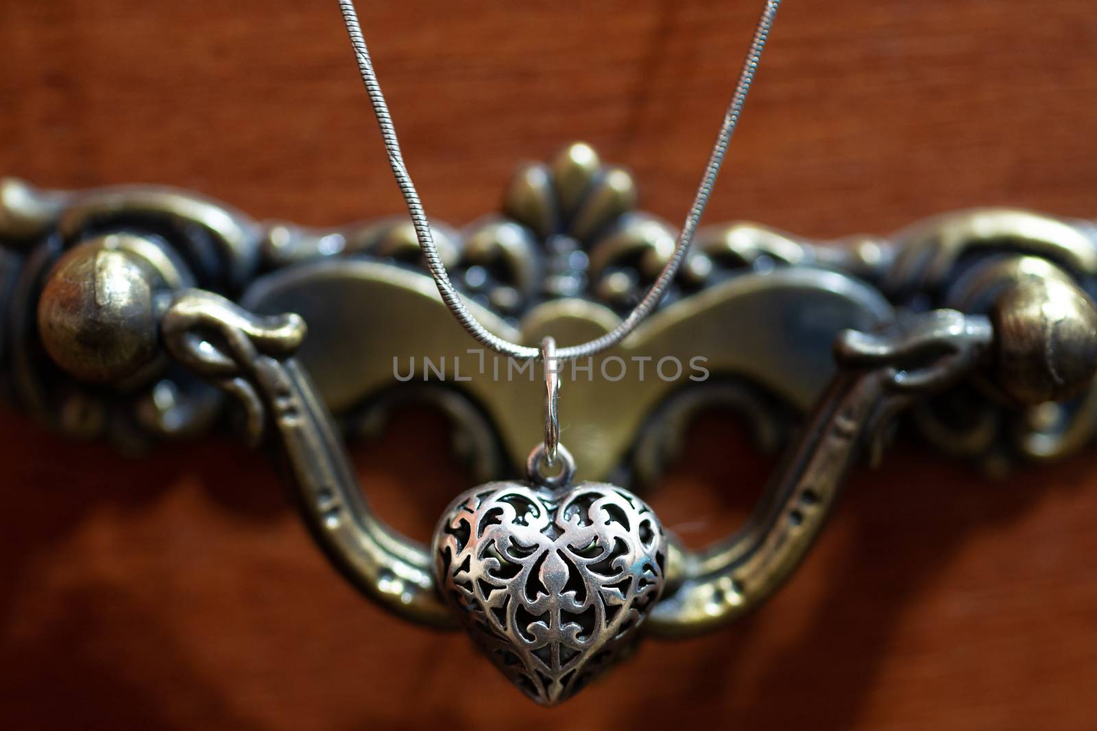 Close up photo of female neck silver pendand on blurred background. A handwork sterling silver pendant look as heart. Macrophoto with blurred background. by alexsdriver