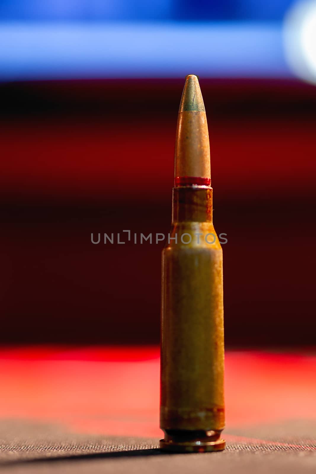 Rifle AK-47 ammo bullet close-up on blurred background. Armor piercing cartridge. by alexsdriver